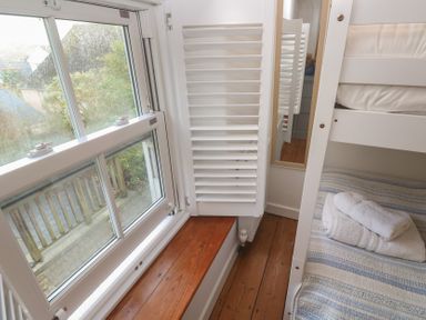 A bedroom with a bunk bed and a window at Bodillys Cottage in Newlyn