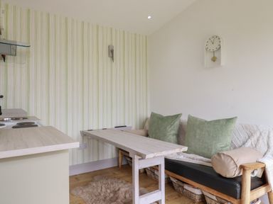 A kitchen with a table and sofa at The Tinystore in Bodmin