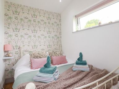 A bedroom with a bed and towels arranged at The Tinystore in Bodmin
