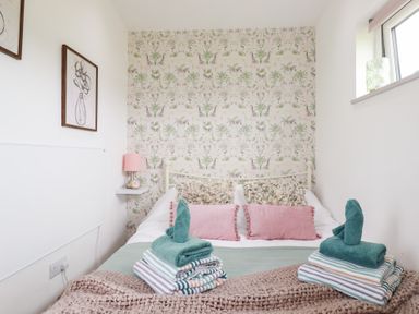 A bedroom with a bed and towels arranged at The Tinystore in Bodmin
