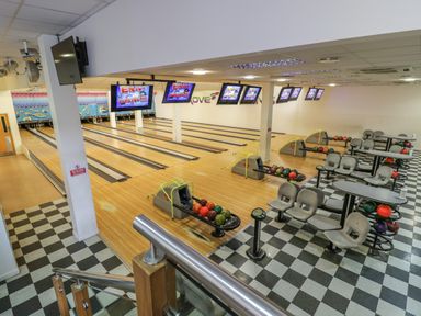 A bowling alley with multiple lanes seating and bowling balls at Grove Cottage in Leominster