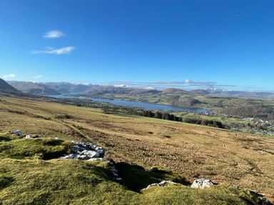 A landscape view of fields hills and a lake under a blue sky at Winder Barn in Askham Cumbria