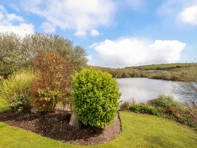 A lake with shrubs and trees around it under a partly cloudy sky at Lake View 10 in Par