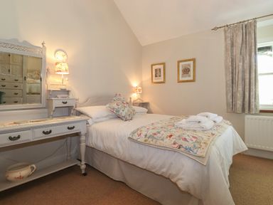 A bedroom with a bed a dressing table and bedside lamps at High Stile Seatoller near Rosthwaite