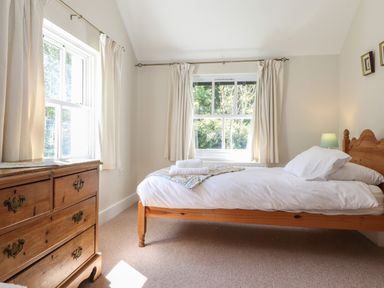 A bedroom with a bed and chest of drawers near windows at High Stile in Seatoller near Rosthwaite