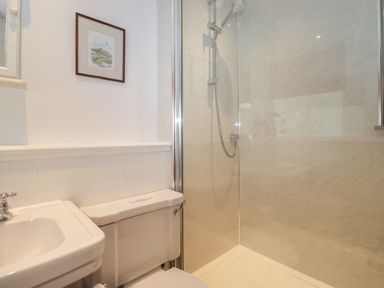 A bathroom with a sink toilet shower and framed picture on the wall at High Stile in Seatoller near Rosthwaite