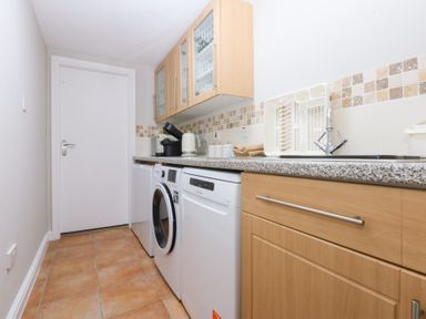 A laundry room with a washing machine and a dishwasher at Oak Cottage in Dinas Dinlle near Caernarfon