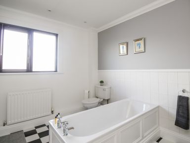 A bathroom with a bathtub toilet and window at Mill End in Eamont Bridge near Penrith