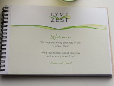 A spiral bound welcome booklet on a white surface at Lyme Zest in Lyme Regis