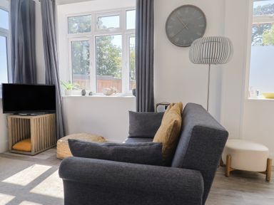 A living room with a sofa and television at Lyme Zest in Lyme Regis