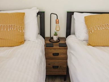 A bedroom with two beds and a nightstand at Lyme Zest in Lyme Regis