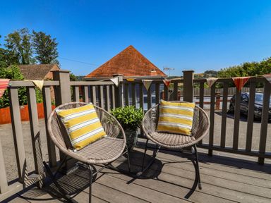 An outdoor seating area with two chairs and a planter at Lyme Zest in Lyme Regis