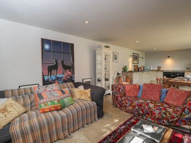A living room with two sofas covered with patterned throws and cushions at Brandeers Long Barn in Brandier near Minety