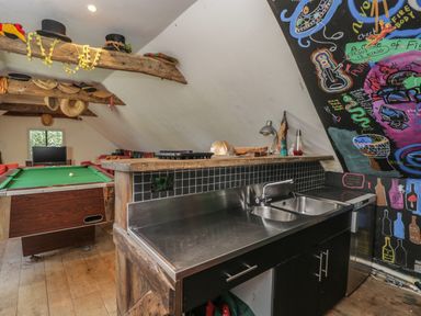 A game room with a pool table a stainless steel kitchen sink and colorful wall art at Brandeers Long Barn Brandier near Minety