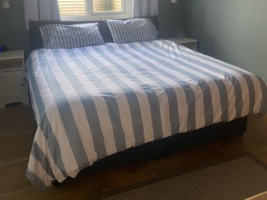 A bedroom with a bed and bedside table at Seaspray in St Bees