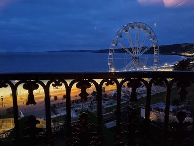 A night view of a ferris wheel near the sea with a decorated railing in the foreground at The Seahome in Scarborough