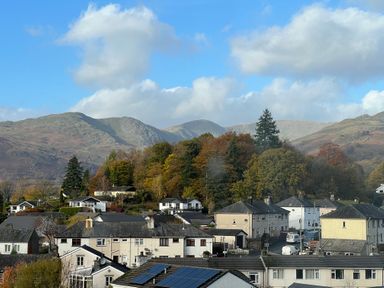 Residential houses with trees and hills in the background at Fairfield View in Ambleside