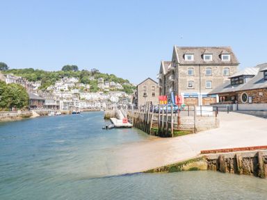 A river with boats and buildings along the shore at 3 River View in Looe