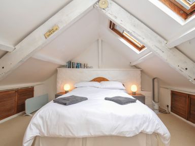 A bedroom with a bed and bedside lamps at 3 River View in Looe