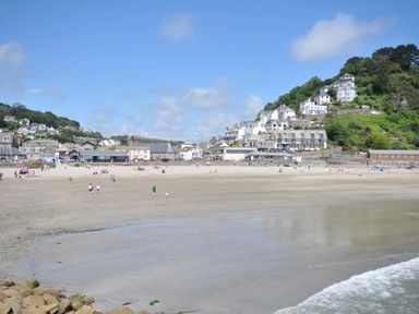 A beach scene with people and houses at 3 River View in Looe