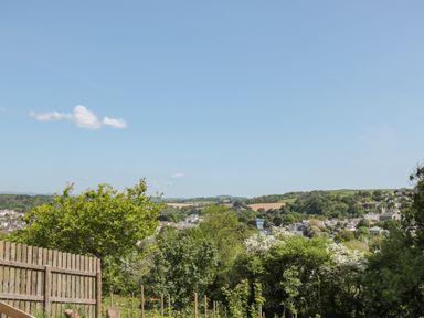 A landscape view with trees wooden fence and distant houses at Dart View Hideout in Totnes