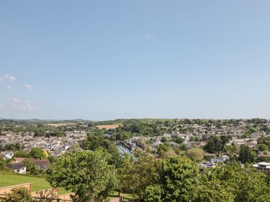 A town with houses trees and a river under a clear sky at Dart View Hideout in Totnes