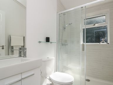 A bathroom with a sink a toilet and a shower enclosure with a window at Bluebell Lodge in Norton near Dartmouth