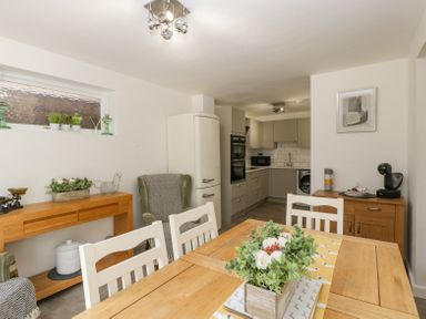 A kitchen and dining area with wooden table and chairs plants on table and sideboard at 4 Wallflower Row Mordiford near Hereford