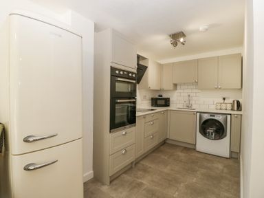 A kitchen with a cream fridge freezer built in ovens microwave washing machine and beige cabinets at 4 Wallflower Row Mordiford near Hereford