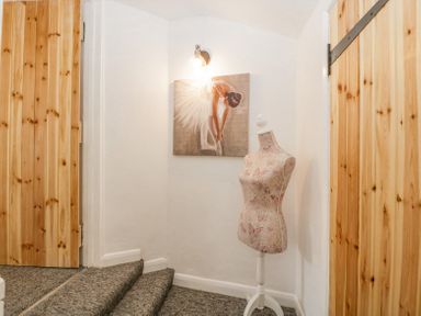 A hallway with carpeted stairs wooden doors a mannequin and a painting of a ballerina at 4 Wallflower Row Mordiford near Hereford