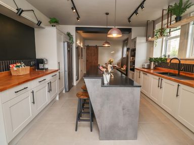 A kitchen with an island in the center and cabinets along the walls at Glencoe House in Wooler