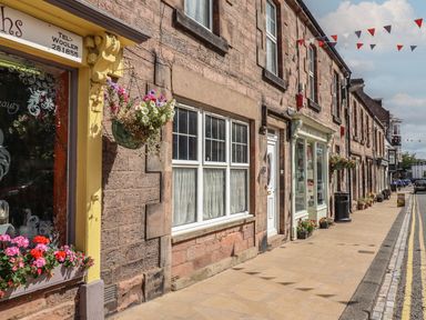 A street with stone buildings and flower decorations at Glencoe House in Wooler