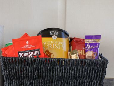 A black basket containing packets of Yorkshire Tea Yorkshire Crisps and Cadbury hot chocolate at Foxglove Lodge in Runswick Bay near Staithes