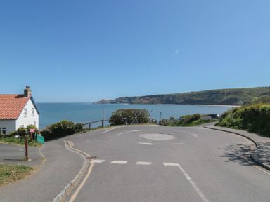 A view of the ocean and cliffs near a house at Rose Lodge Runswick Bay near Staithes