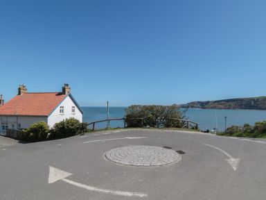 A roundabout with a house and sea view at Honeysuckle Lodge Runswick Bay near Staithes