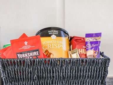A woven basket containing packets of Yorkshire Tea Yorkshire Crisps Cadbury hot chocolate and other snacks at Lilac Lodge in Runswick Bay near Staithes