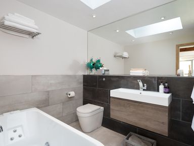 A bathroom with a bathtub toilet sink towels and a large mirror at Shepherds View in Dufton near Appleby-in-Westmorland