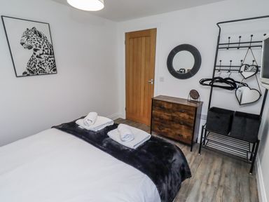 A bedroom with a bed and dresser at Old Colliery Cottage in Shilbottle