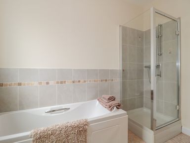 A bathroom with a bathtub and a glass-enclosed shower at Cherry Tree House in Highbridge