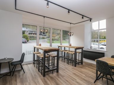 A cafe with tables and barstools at Beech Timber Lodge in Keswick