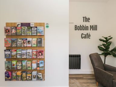A brochure rack and seating area at The Bobbin Mill Café in Keswick
