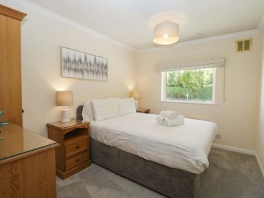 A bedroom with a bed and nightstands at Beech Timber Lodge in Keswick