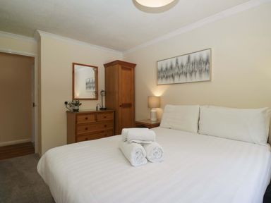 A bedroom with a bed and wooden furniture at Beech Timber Lodge in Keswick