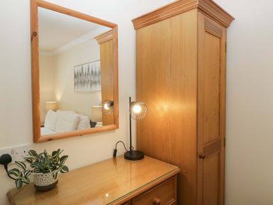 A bedroom with a mirror and a dresser at Beech Timber Lodge in Keswick