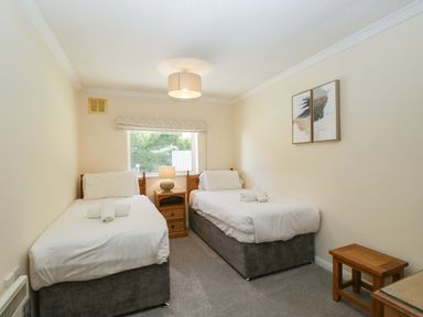 A bedroom with two beds and a table with a lamp at Beech Timber Lodge in Keswick