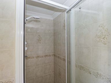 A shower area with tiles and glass door at Beech Timber Lodge in Keswick