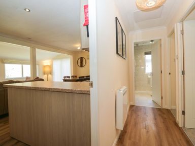 A hallway with access to kitchen and bathroom at Beech Timber Lodge in Keswick