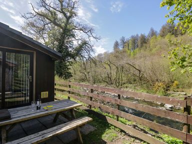An outdoor seating area with a table and chairs at Beech Timber Lodge in Keswick