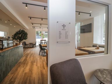 A cafe with seating and menu board at The Bobbin Mill Cafe in Keswick