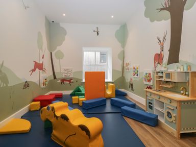 A playroom with soft play blocks and a play kitchen at Elm Lodge in Keswick